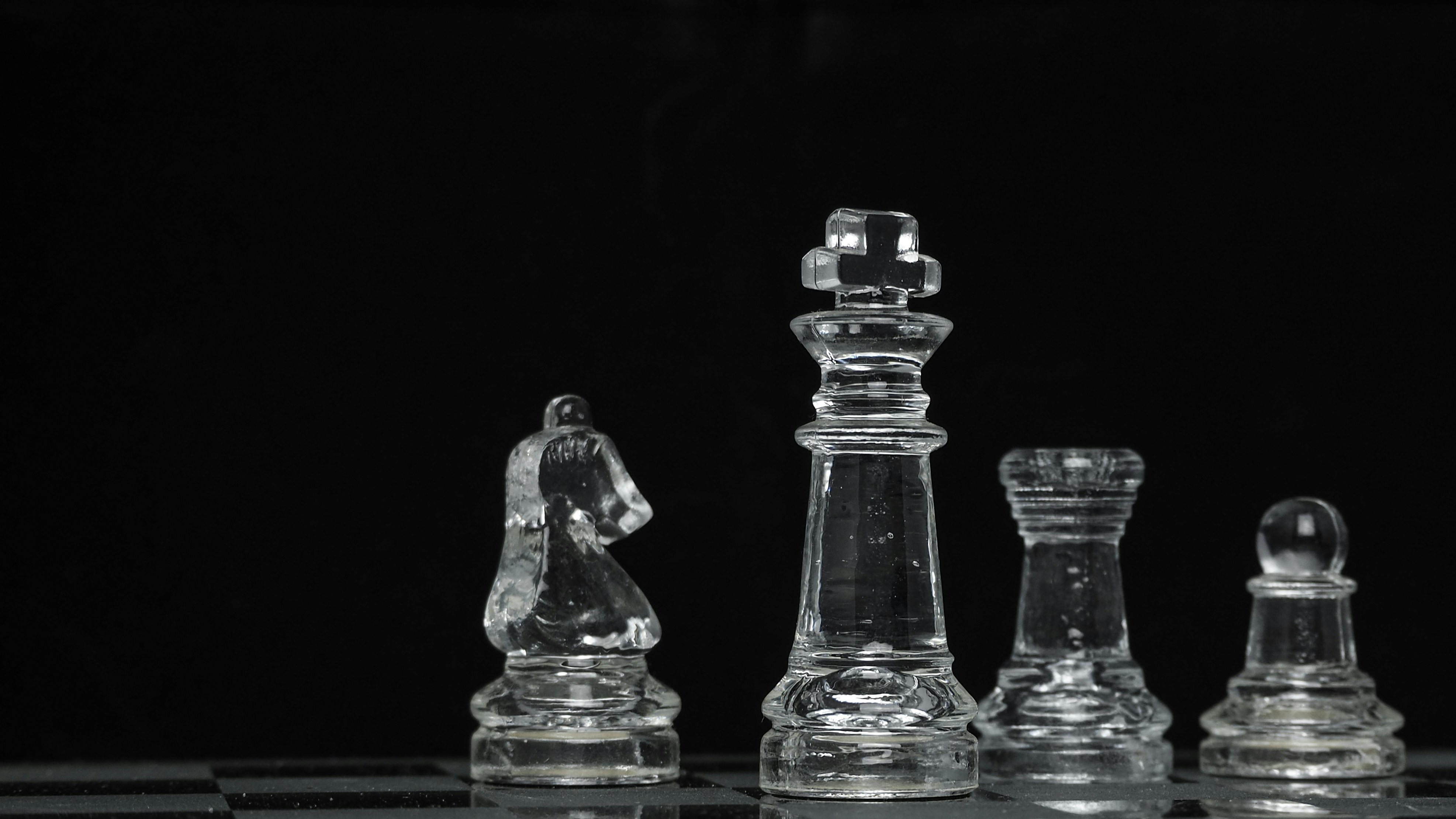Businessman analyzing chess pieces symbolizing business strategy